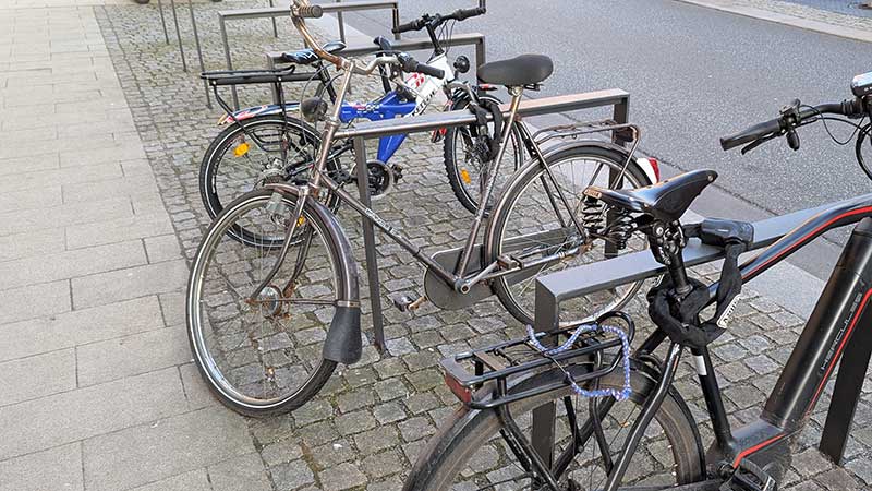 Fahrräder draußen am Metallbügel angeschlossen