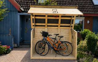 Schmale Fahrradgarage aus Holz für zwei Fahrräder mit geöffnetem Dach